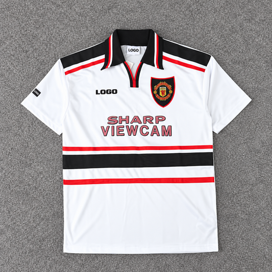 Manchester United · Blanca SHARP VIEWCAM · Retro. Fotografía editada con escudo conservado y marcas deportivas sustituidas por LOGO.